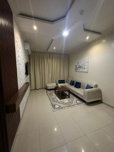 una sala de estar con un sofá y una mesa en Aldaar apartments, en Al Bukayriyah