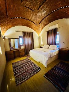a bedroom with a large bed and two rugs at فيلا جاكرندا تونس Jacaranda Villa Tunis in Fayoum +53 photos