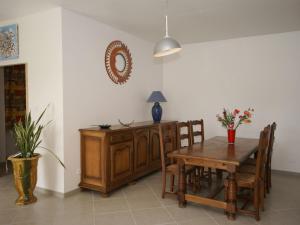 a dining room with a table and a table and chairs at Serene Holiday Home in Pradons with Swimming Pool in Pradons