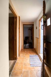 a hallway with a door and a tile floor at Vivienda de Turismo Rural Granja La Lomica in Ladruñán