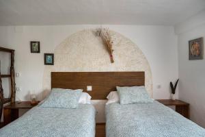 a bedroom with two beds and a wall at Vivienda de Turismo Rural Granja La Lomica in Ladruñán