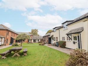 une vue de la cour d'une maison avec une table de pique-nique dans l'établissement Rushmoor Cottage, à Colaton Raleigh