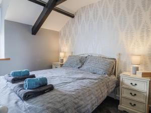 une chambre avec un lit avec des oreillers bleus dessus dans l'établissement Rushmoor Cottage, à Colaton Raleigh