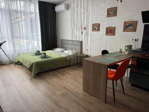 a bedroom with a bed and a desk and a table at Atmosfera Sea View Apartments in Odesa