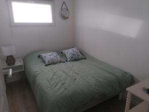 a bedroom with a bed with two pillows on it at Le chalet d'Opale in Sangatte