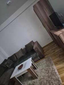 una sala de estar con un sofá y una mesa en Maki Aki Apartman, en Jagodina