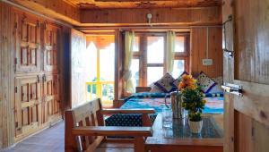 a bedroom with a bed and a table with flowers on it at Himalayan Homestay Gadagusain in Jibhi