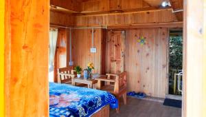 a bedroom with a bed and a table and chairs at Himalayan Homestay Gadagusain in Jibhi