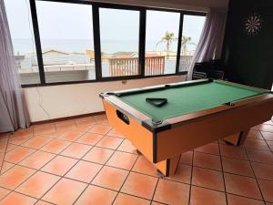 a pool table in a room with a view of the beach at JJs At The Sea in Margate