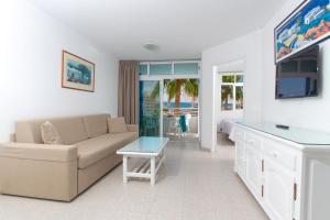 a living room with a couch and a tv at Apartamentos Tamaragua in Playa del Ingles