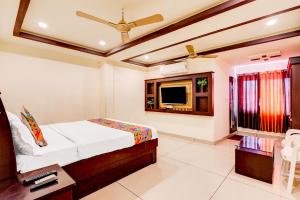 a bedroom with a bed and a flat screen tv at FabHotel Alfa in Vijayawāda