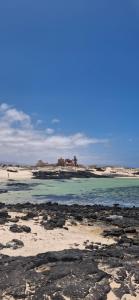 a beach with rocks and the ocean in the background at Casa Cactus in Cotillo