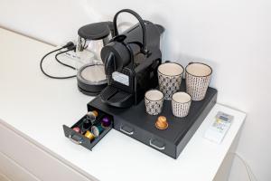 eine schwarze Kaffeemaschine und Tassen auf einer Theke in der Unterkunft Ampia stanza moderna Venezia a 10 minuti in Venedig + 18 Fotos