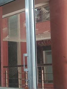 een glazen deur met een raam in een gebouw bij Hotel navneet in Bahādrābād
