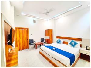 Un dormitorio con una cama, un escritorio y un televisor. en HOTEL " THE RAM KRISHNA " Walking Distance From SHREE RAM JANAM BHOOMI - EXCELLENT HOSPITALITY WITH MODERN AMENITIES, en Ayodhya