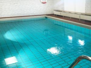 a large swimming pool with blue water at Ocean-View-I-Holiday-Apartments-Sylt in Rantum