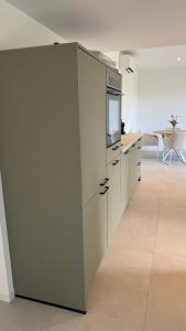a kitchen with white cabinets and a counter top at B&B Ztrand in Oudesluis