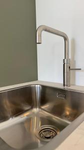a stainless steel kitchen sink with a faucet at B&B Ztrand in Oudesluis