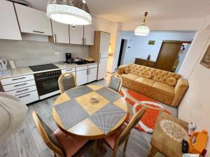 a kitchen and living room with a table and a couch at Panoramic La Cetate in Tîrgu Neamţ