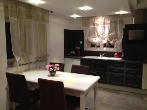 a kitchen with a white table and chairs and a sink at la menuiserie in Jeuxey