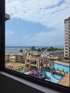 a view of a pool from a hotel window at Almasi Suites at Sandyshore Beach Resort in Kikambala