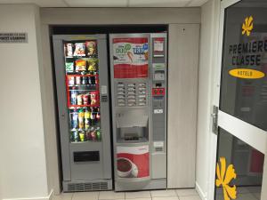 two vending machines in a building with drinks in them at Premiere Classe Toulouse Sud - Portet in Portet-sur-Garonne