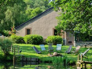 a group of chairs sitting in the grass next to a building at Gite de Liresse 