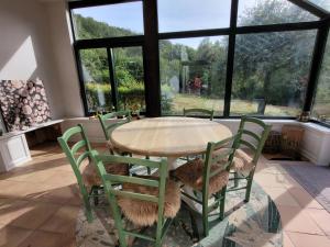 a table and chairs in a room with windows at Gite de Liresse  +4 photos