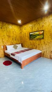 a bedroom with a bed in a wooden wall at Du già Mit's homestay in Yên Minh