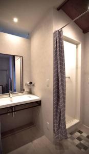 a bathroom with a sink and a shower curtain at the lounge Kamakura HASE in Kamakura