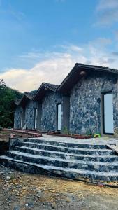 a stone house with stairs in front of it at Du già Mit's homestay in Yên Minh