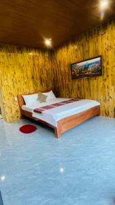 a bedroom with a bed in a wooden wall at Du già Mit's homestay in Yên Minh +2 photos