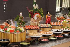 a buffet with many different types of food in wooden barrels at Daisy Apartment & Hotel Cẩm Phả in Hòn Một