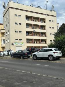 ein Parkplatz mit vor einem Gebäude geparkten Autos in der Unterkunft Apartament na Pogodnie in Stettin