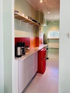 eine Küche mit einem roten Kühlschrank im Zimmer in der Unterkunft Apartament na Pogodnie in Stettin