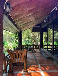 Ban Nam Tok Mae KlangPrivate Forest Cottage in Near Chiang Mai的天井上设有木凳的门廊