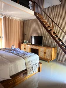 1 dormitorio con 1 cama y escalera con TV en Bale Penida Villa, en Nusa Penida 50 fotos más