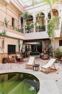 a courtyard with a pool in front of a building at Les Sources Berbères Riad & Spa in Marrakech
