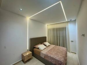 a small bedroom with a bed and a window at Apartment in Mehdia Beach in Kenitra