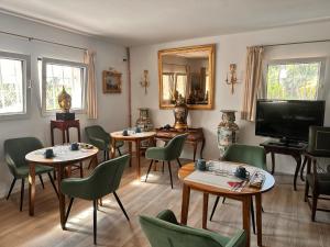 a room with tables and chairs and a flat screen tv at Villa IRI Habitación N 4 - Suit con balcón in Pineda de Mar