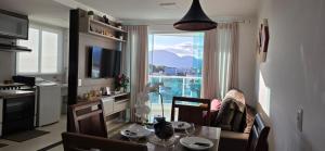 un soggiorno con tavolo e una cucina con finestra di Vista para as Montanhas a Guarapari