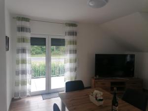 a living room with a television and a dining room table at Haus Kleeblatt in Cochem