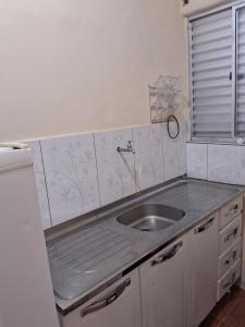 a kitchen counter with a sink and a window at Recanto feliz in São Thomé das Letras