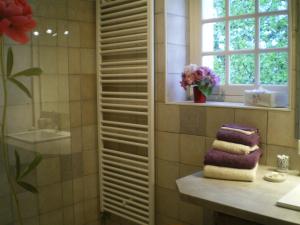 a bathroom with a window and a pile of towels at la MAISON de FRAMBOISE in Civray-de-Touraine +3 photos