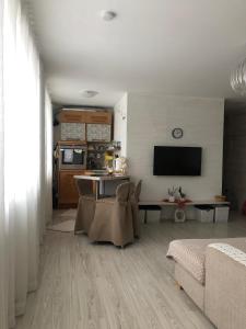 een keuken en woonkamer met een tafel en stoelen bij Järveküla in Kohtla-Järve