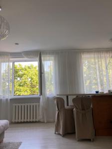 ein Wohnzimmer mit zwei Stühlen und zwei Fenstern in der Unterkunft Järveküla in Kohtla-Järve + 14 Fotos