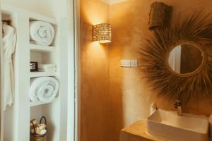 a bathroom with a sink and a mirror on the wall at La Perla Beach Resort, Zanzibar - Your Beachfront Private Haven in Pwani Mchangani