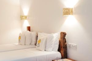 two beds in a room with white sheets and pillows at La Perla Beach Resort, Zanzibar - Your Beachfront Private Haven in Pwani Mchangani