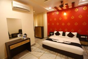 a bedroom with a large bed with a red wall at Vipul Estate in Kausani