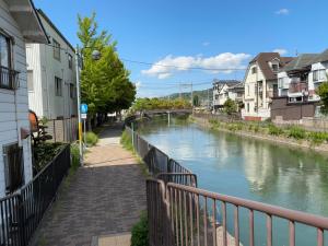 une rivière dans une ville avec des maisons et un pont dans l'établissement Happy Inn Kyoto えんの宿, à Kyoto